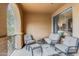 Cozy balcony featuring ample cushioned seating and view of the neighborhood through arched entryway at 10655 N 9Th St # 207, Phoenix, AZ 85020
