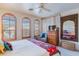 Relaxing bedroom with ceiling fan, shuttered windows, and decorative mirror enhancing the room's charm at 10655 N 9Th St # 207, Phoenix, AZ 85020