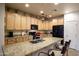 Well-lit kitchen boasts granite countertops, wooden cabinetry, and black appliances at 10655 N 9Th St # 207, Phoenix, AZ 85020
