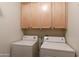 Practical laundry area featuring matching washer and dryer with built-in cabinets above for convenient storage at 10655 N 9Th St # 207, Phoenix, AZ 85020