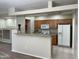 Open kitchen with breakfast bar, white appliances, and tile flooring at 11500 E Cochise Dr # 1063, Scottsdale, AZ 85259