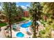 Aerial view of the community pool and spa surrounded by mature trees, desert landscaping, lounge seating, and shade umbrellas at 12212 N Paradise Village S Pkwy # 444, Phoenix, AZ 85032