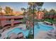 An aerial view of the community pool with rock features, waterfalls, lounge seating, and desert landscaping at 12212 N Paradise Village S Pkwy # 444, Phoenix, AZ 85032