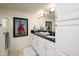 Bathroom featuring double sinks, framed mirror, black counters, and white cabinets at 12212 N Paradise Village S Pkwy # 444, Phoenix, AZ 85032