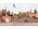 Gated community entrance featuring desert landscaping, terracotta colored buildings, and the American flag at 12212 N Paradise Village S Pkwy # 444, Phoenix, AZ 85032