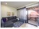 Cozy living room featuring a comfortable sofa, a sliding glass door, and a private balcony at 12212 N Paradise Village S Pkwy # 444, Phoenix, AZ 85032