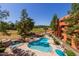 Community pool and spa with lounge seating, shade umbrellas, rock feature with waterfall, desert landscaping and mature trees at 12212 N Paradise Village S Pkwy # 444, Phoenix, AZ 85032