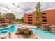 Community pool features rock formations, a waterfall, lounge seating and shade umbrellas surrounded by mature desert landscaping at 12212 N Paradise Village S Pkwy # 444, Phoenix, AZ 85032
