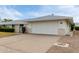 Charming single-story home with a two-car garage, manicured bushes, and small decorative entry gate at 12939 W Prospect Dr, Sun City West, AZ 85375