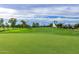 Beautiful green putting area on the golf course surrounded by trees and a blue sky at 12939 W Prospect Dr, Sun City West, AZ 85375
