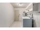 Bright laundry room featuring tile flooring, washer, dryer, storage shelves, and convenient access door at 12939 W Prospect Dr, Sun City West, AZ 85375
