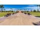 Park featuring walking paths, benches, and mature palm trees under a clear blue sky at 12939 W Prospect Dr, Sun City West, AZ 85375