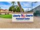 Liberty Courts Pickleball Center sign with manicured landscape and community buildings in background at 12939 W Prospect Dr, Sun City West, AZ 85375