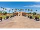 Community recreation area with a building, benches and tall palm trees against blue sky at 12939 W Prospect Dr, Sun City West, AZ 85375
