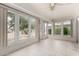 Bright sunroom featuring large windows, neutral tile flooring, and a ceiling fan for comfortable living at 12939 W Prospect Dr, Sun City West, AZ 85375