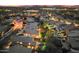 Night aerial view showcasing an illuminated community with pool, putting green, and lush landscaping at 16044 N 106Th Way, Scottsdale, AZ 85255