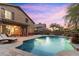 Inviting backyard showcasing a sparkling pool with waterfall feature, patio, and outdoor dining space at 16044 N 106Th Way, Scottsdale, AZ 85255