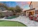 Relaxing backyard oasis featuring a sparkling pool with water feature, putting green, and lounge chairs for outdoor enjoyment at 16044 N 106Th Way, Scottsdale, AZ 85255
