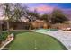 Backyard view with putting green, lush landscaping, and resort-style pool at 16044 N 106Th Way, Scottsdale, AZ 85255