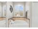Relaxing bathroom with soaking tub, neutral tones, and window shutters at 16044 N 106Th Way, Scottsdale, AZ 85255