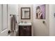 Cozy powder room featuring a wooden vanity, brushed nickel faucet, and Audrey Hepburn wall art at 16044 N 106Th Way, Scottsdale, AZ 85255