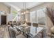 Open-concept dining room with modern chandelier, plantation shutters, and hardwood floors at 16044 N 106Th Way, Scottsdale, AZ 85255