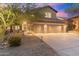 Charming home featuring a well-manicured landscape, stone accents, and a three-car garage under a gorgeous twilight sky at 16044 N 106Th Way, Scottsdale, AZ 85255