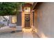 Inviting entryway with a dark wood door, decorative wreath, elegant lighting, and neutral stucco wall at 16044 N 106Th Way, Scottsdale, AZ 85255