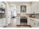 Stylish kitchen featuring white cabinets, stainless steel appliances, light grey backsplash, and wood-look flooring at 16044 N 106Th Way, Scottsdale, AZ 85255