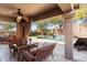 Stylish covered patio with comfortable seating, a ceiling fan, and views of the pool and backyard at 16044 N 106Th Way, Scottsdale, AZ 85255