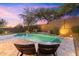 Relaxing backyard pool area with lounge chairs, a waterfall feature, and lush landscaping at 16044 N 106Th Way, Scottsdale, AZ 85255