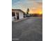 Exterior view of a residential building with a gravel yard and a beautiful sunset in the background at 1618 S Cedar Dr, Apache Junction, AZ 85120