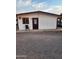 Exterior view of a building featuring a gravel yard and a white exterior, highlighted by brown trim around windows and doors at 1618 S Cedar Dr, Apache Junction, AZ 85120