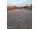 Street view of a property, showcasing the gravel driveway and the serene, tree-lined neighborhood at 1618 S Cedar Dr, Apache Junction, AZ 85120