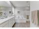 Bathroom features a double sink vanity, soaking tub, and walk-in shower with gray wood floors at 17145 W Hadley St, Goodyear, AZ 85338
