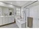 Bathroom features a double sink vanity, soaking tub, and walk-in shower with gray wood floors at 17145 W Hadley St, Goodyear, AZ 85338