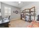 Bedroom with desk, shelving, and a bright window with shutters at 17145 W Hadley St, Goodyear, AZ 85338
