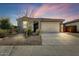 Charming single-story home with a two-car garage, xeriscape landscaping, and neutral stucco exterior at 17145 W Hadley St, Goodyear, AZ 85338