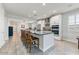 Well-lit kitchen boasts a large island with seating, stainless steel appliances, and decorative backsplash at 17145 W Hadley St, Goodyear, AZ 85338