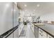 Stylish kitchen featuring stainless steel appliances, white cabinets, and an expansive island overlooking the living area at 17145 W Hadley St, Goodyear, AZ 85338