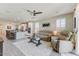 Open-concept living room adjacent to a modern kitchen with stylish furnishings and ample natural light at 17145 W Hadley St, Goodyear, AZ 85338