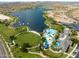 Expansive aerial view showcasing a lakefront community with a luxurious pool, clubhouse, and green spaces at 18346 W Sweet Acacia Dr, Goodyear, AZ 85338