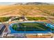 Aerial view of Estrella Foothills High School, showcasing football and baseball fields with desert mountain views in the background at 18346 W Sweet Acacia Dr, Goodyear, AZ 85338