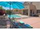 Lounge chairs by the pool and covered patio create a relaxing backyard oasis at 18346 W Sweet Acacia Dr, Goodyear, AZ 85338