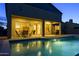 Backyard patio and pool illuminated at dusk, complete with outdoor dining area and landscaping at 18346 W Sweet Acacia Dr, Goodyear, AZ 85338