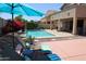 Inviting backyard featuring a swimming pool, lounge chairs, and covered patio at 18346 W Sweet Acacia Dr, Goodyear, AZ 85338