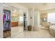 Bright bathroom featuring double closets, a walk-in shower, and a soaking tub at 18346 W Sweet Acacia Dr, Goodyear, AZ 85338