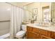 Well-lit bathroom features a shower-tub combo and wood cabinets under the sink with updated fixtures at 18346 W Sweet Acacia Dr, Goodyear, AZ 85338