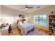 Bright bedroom features a window with natural light, desk, ceiling fan, and laminate wood floors at 18346 W Sweet Acacia Dr, Goodyear, AZ 85338