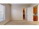 Carpeted bedroom features a window for natural light and access to a spacious walk-in closet at 18346 W Sweet Acacia Dr, Goodyear, AZ 85338